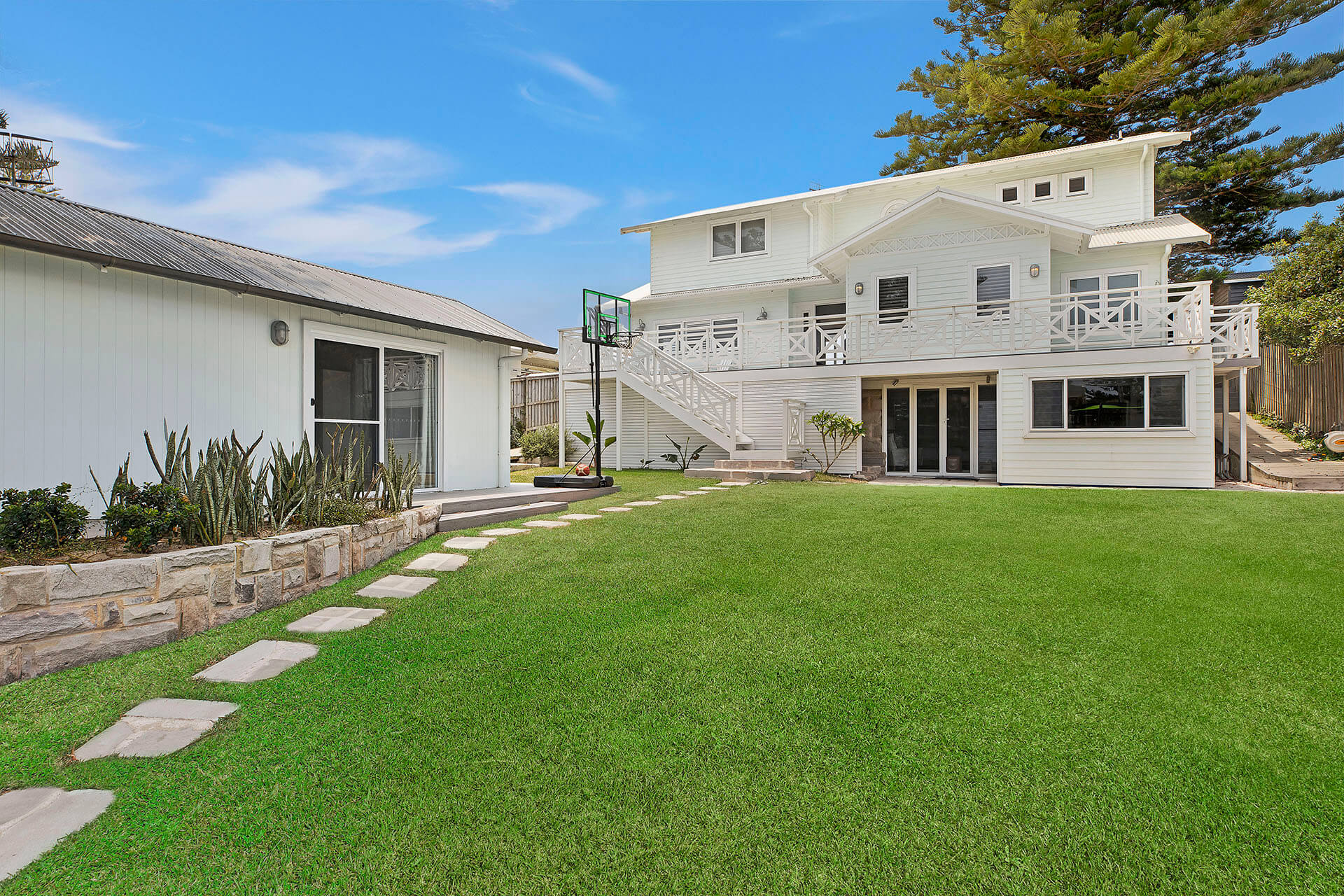 Three-storey wooden beach home with large grass area and studio